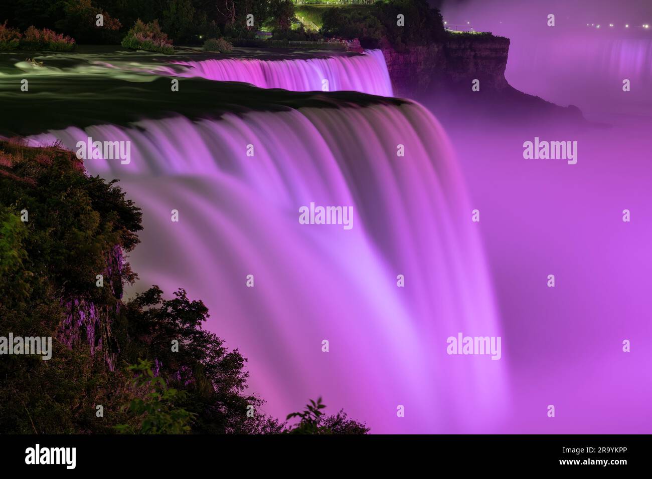 Die Niagarafälle, NY, USA, werden nachts von violetten Lichtern beleuchtet Stockfoto