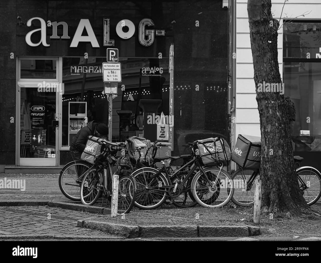 Drei schwarz-weiße Fahrräder, die vor einem Gebäude geparkt sind Stockfoto