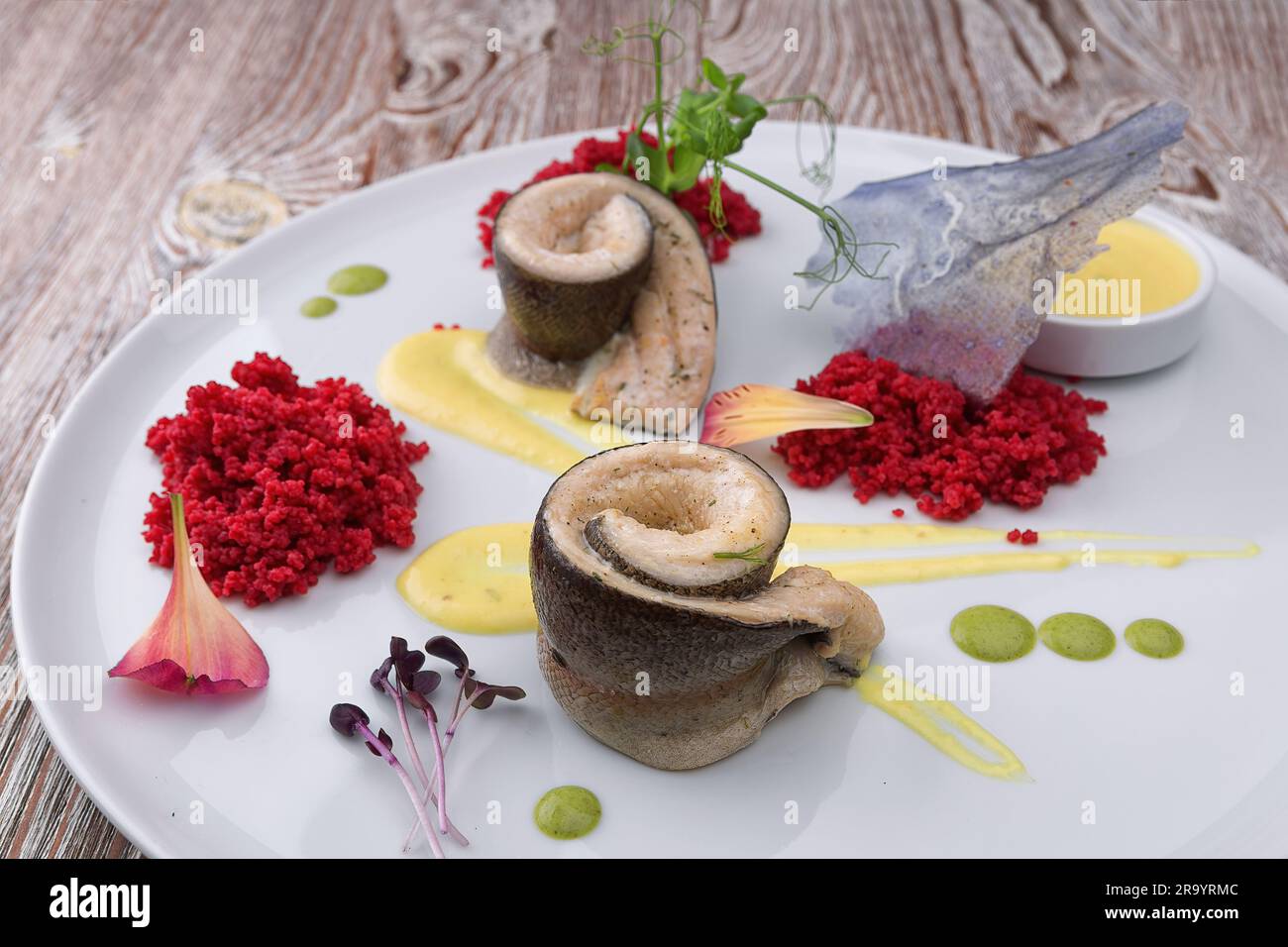 Gebratenes Heringsfilet mit Sauce auf einem weißen Teller Stockfoto