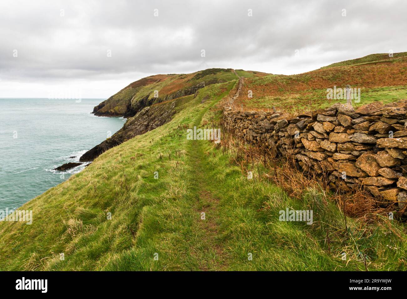 Anglesey North Coastal Path, Wales. Herbst- oder Herbstpfad mit trockener Steinmauer und Meer in der Ferne, Landschaft, Weitwinkel Stockfoto