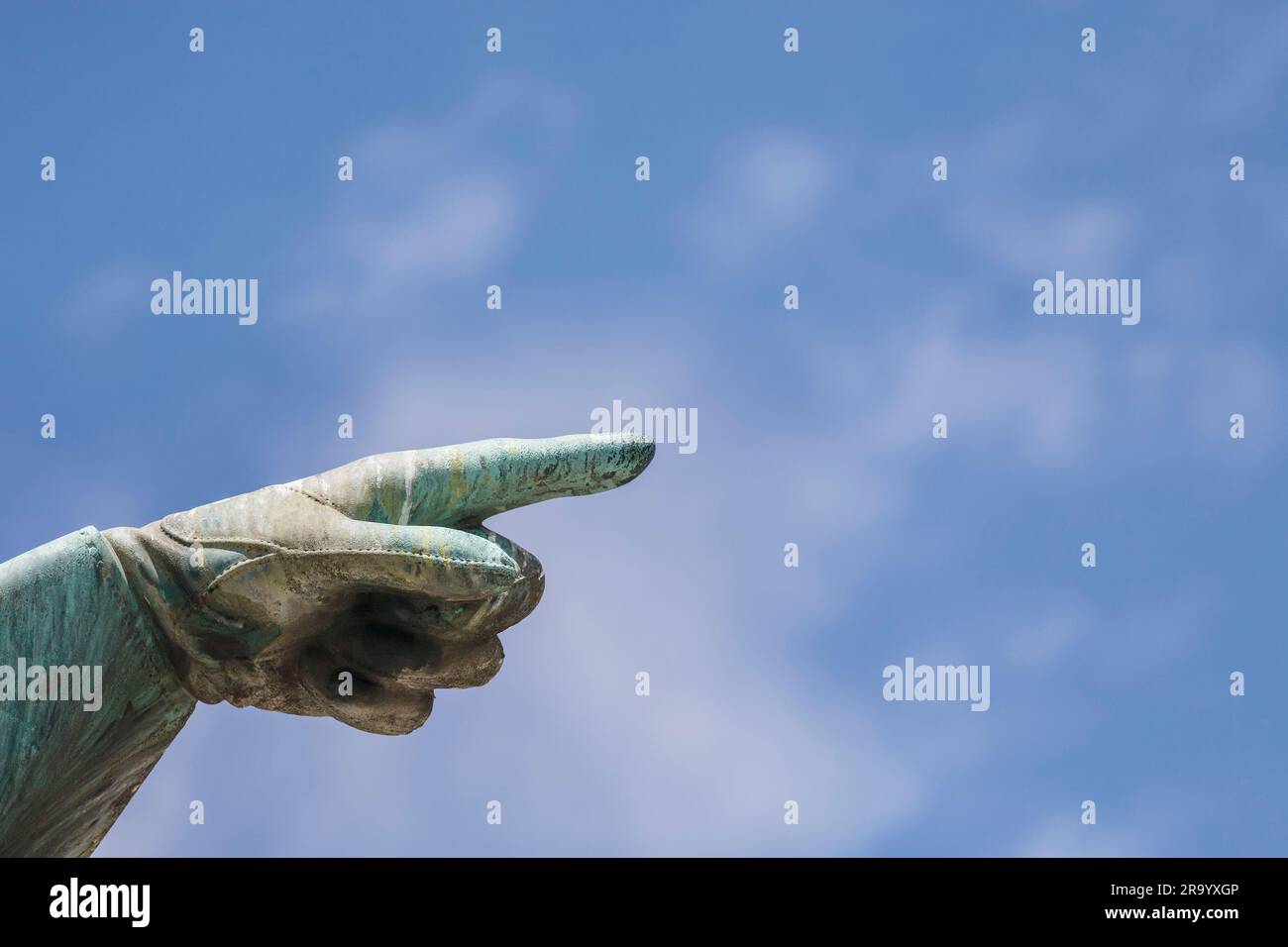 Nahaufnahme einer Hand, die mit dem Zeigefinger gegen den blauen Himmel zeigt. Statue des Karl XII. Königs von Schweden in Kungstradgarden, Stockholm. Schweden. Stockfoto