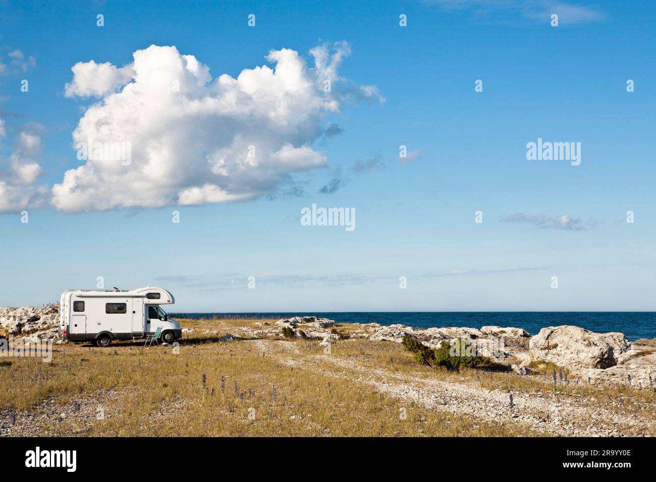 Seitenansicht eines Wohnwagens, das am Strand am Meer unter Wolken am Himmel zeltet. Gotland Island, Schweden. Stockfoto