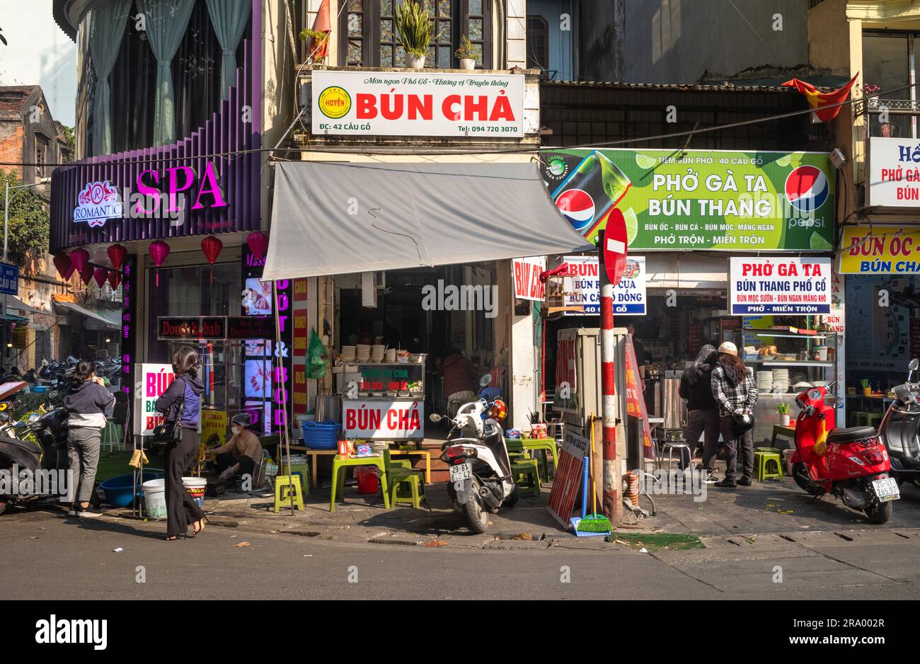Die Leute durchstöbern kleine Restaurants und Geschäfte in der Altstadt, Hanoi, Vietnam. Stockfoto