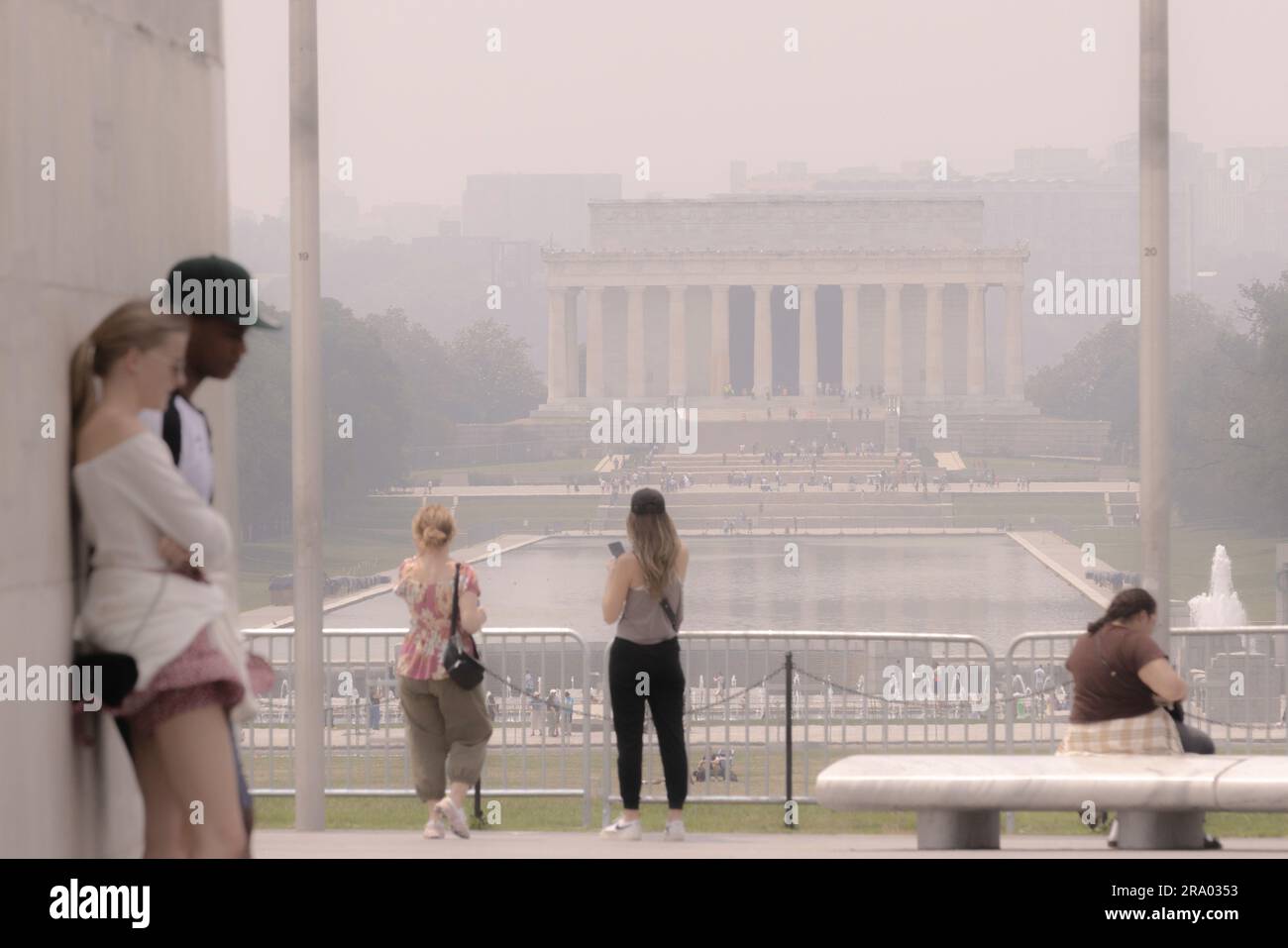 Washington, USA. 29. Juni 2023. Am 29. Juni 2023 werden Menschen mit dem Lincoln Memorial in Washington, DC, USA, im Hintergrund im Dunst bedeckt gesehen. Über 120 Millionen Menschen in mehr als einem Dutzend US-Bundesstaaten, vom Mittleren Westen bis zur Ostküste, sind seit Donnerstag in Alarmbereitschaft, da der Rauch von kanadischen Waldbränden weiterhin im ganzen Land weicht. Kredit: Aaron Schwartz/Xinhua/Alamy Live News Stockfoto