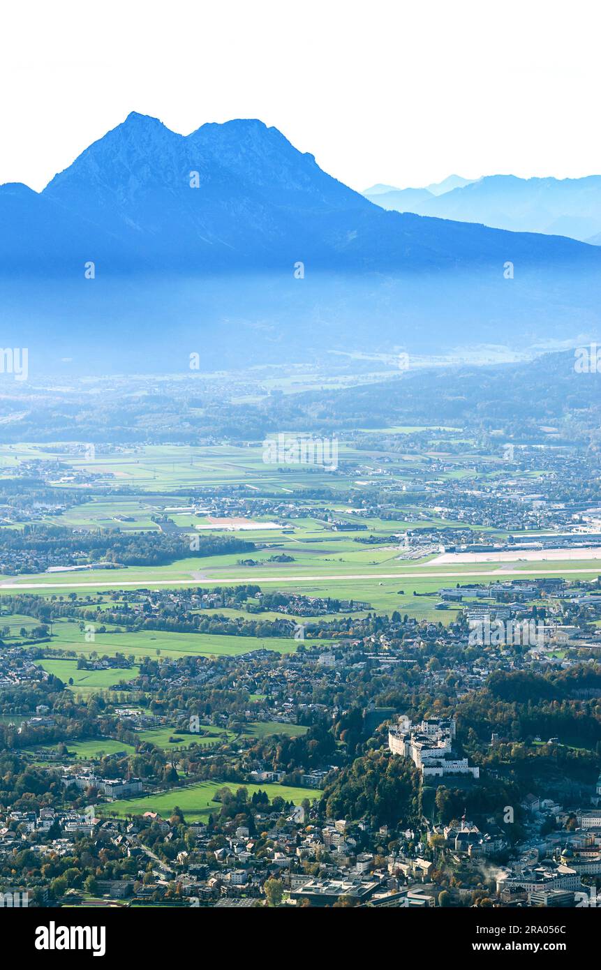 Salzburger Becken vom Gaisberg aus gesehen. Stadt Salzburg in Österreich mit Festung Hohensalzburg, hinter dem Flughafen und den Chiemgau-Alpen. Stockfoto