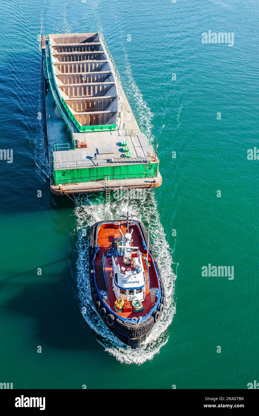 Schleppschiff mit Fracht auf dem Wasser, Luftaufnahme. Schlepper, der leeres Schiff im Hafen von Vancouver, BC, zieht – März 23,2023. Ein Reisefoto, niemand Stockfoto