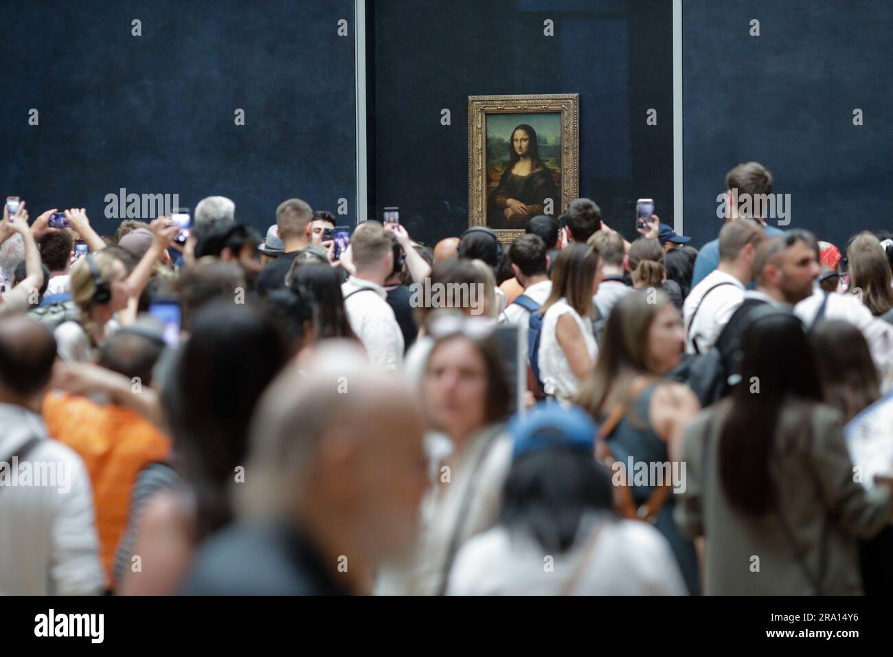 Paris, Frankreich - 9. Juni 2023: Touristenmassen machen Fotos vom berühmten Mona Lisa Gemälde von Leonardo da Vinci im Louvre. Stockfoto