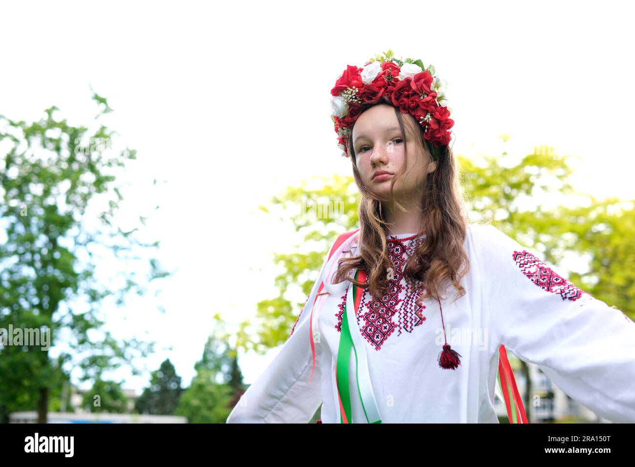 Süßes junges Mädchen, Teenager, ukrainerin, in einem traditionellen Bild, wie sie ihr Haar frisiert. Der Wind weht und entwickelt ihre Locken wunderschöner Kranz mit vielen Blumen Bänder Natur weibliche natürliche Schönheit Leute Stockfoto