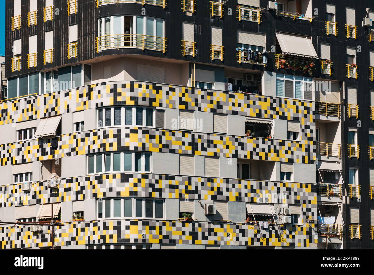 Ein modernes Apartmentgebäude in Tirana, Albanien, mit farbenfrohen gelben, weißen und grauen Fliesen außen Stockfoto