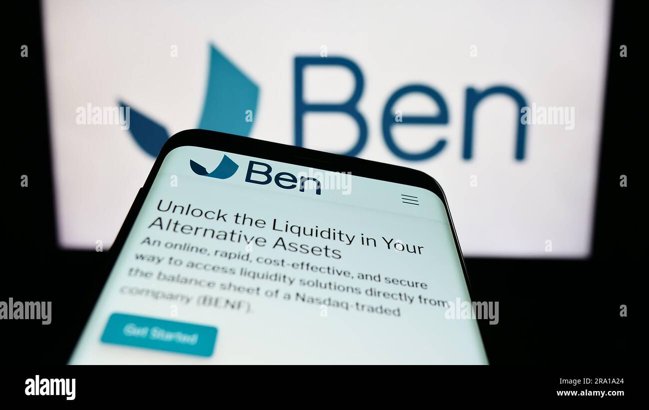 Mobiltelefon mit Website der begünstigten Unternehmensgruppe (Trustben) auf dem Bildschirm vor dem Unternehmenslogo. Fokus auf oberer linker Seite des Telefondisplays. Stockfoto