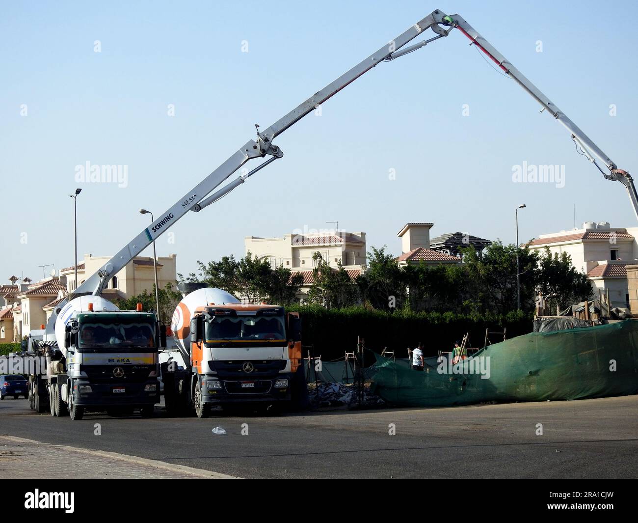Kairo, Ägypten, Juni 17 2023: Eine Lkw-montierte Betonauslegerpumpe am Straßenrand, die Beton in ein neues Gebäude gießt, selektiver Betonfokus Stockfoto