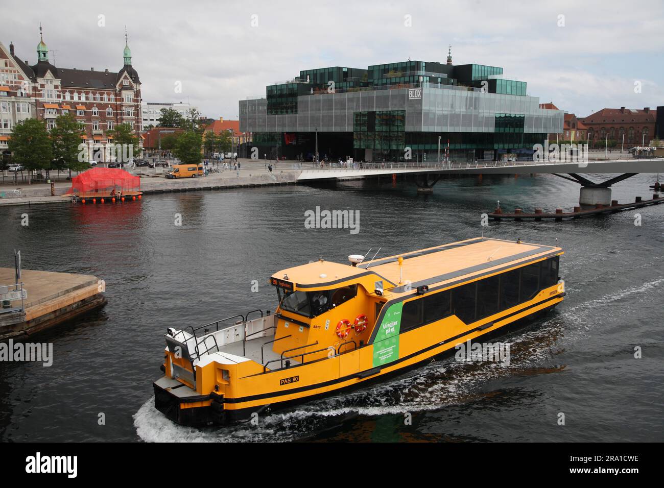 Kopenhagen, Dänemark. 28. Juni 2023. Die Kopenhagener Hafenfähre führt zwischen der Lille Langebro (kleine lange Brücke) und der Langebro (lange Brücke). Im Hintergrund sehen Sie das Blox-Gebäude, in dem auch das Dänische Architekturzentrum untergebracht ist. Auf der linken Seite sehen Sie das rote Dach von „The Raft“, eine Baustelle anlässlich des bevorstehenden Architektenkongresses. In den kommenden Tagen findet in Kopenhagen der 28. Weltkongress der Architekten statt. (Zu dpa 'gesundes Bauen' - wie nachhaltig kann Architektur sein?') Kredit: Steffen Trumpf/dpa/Alamy Live News Stockfoto