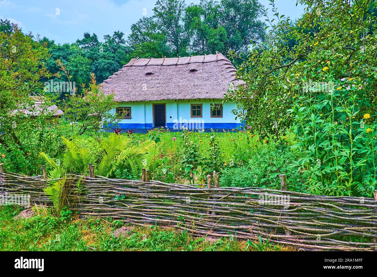 der weidenzaun von tyn, ein blühender Garten und ein traditionelles weiß getünchtes Hatahaus des alten Bukovinianischen Anwesens Chernivtsi scansen, Ukraine Stockfoto