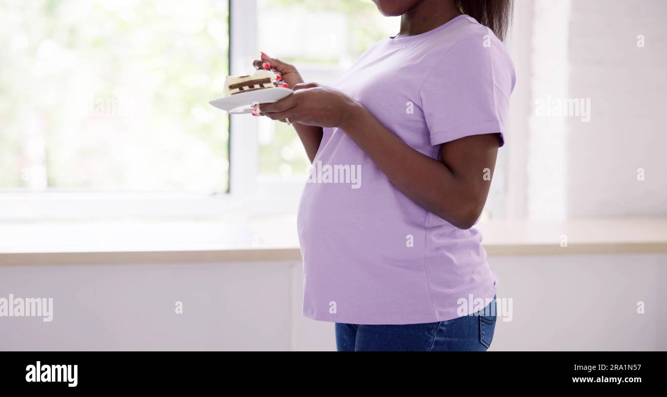 Hungrige Schwangere Frau, Die Im Wohnzimmer Isst Stockfoto