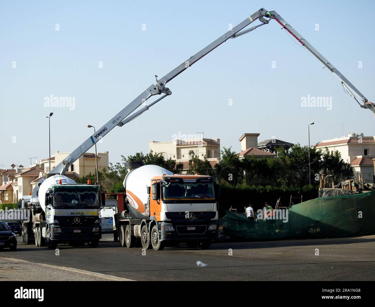 Kairo, Ägypten, Juni 17 2023: Eine Lkw-montierte Betonauslegerpumpe am Straßenrand, die Beton in ein neues Gebäude gießt, selektiver Betonfokus Stockfoto