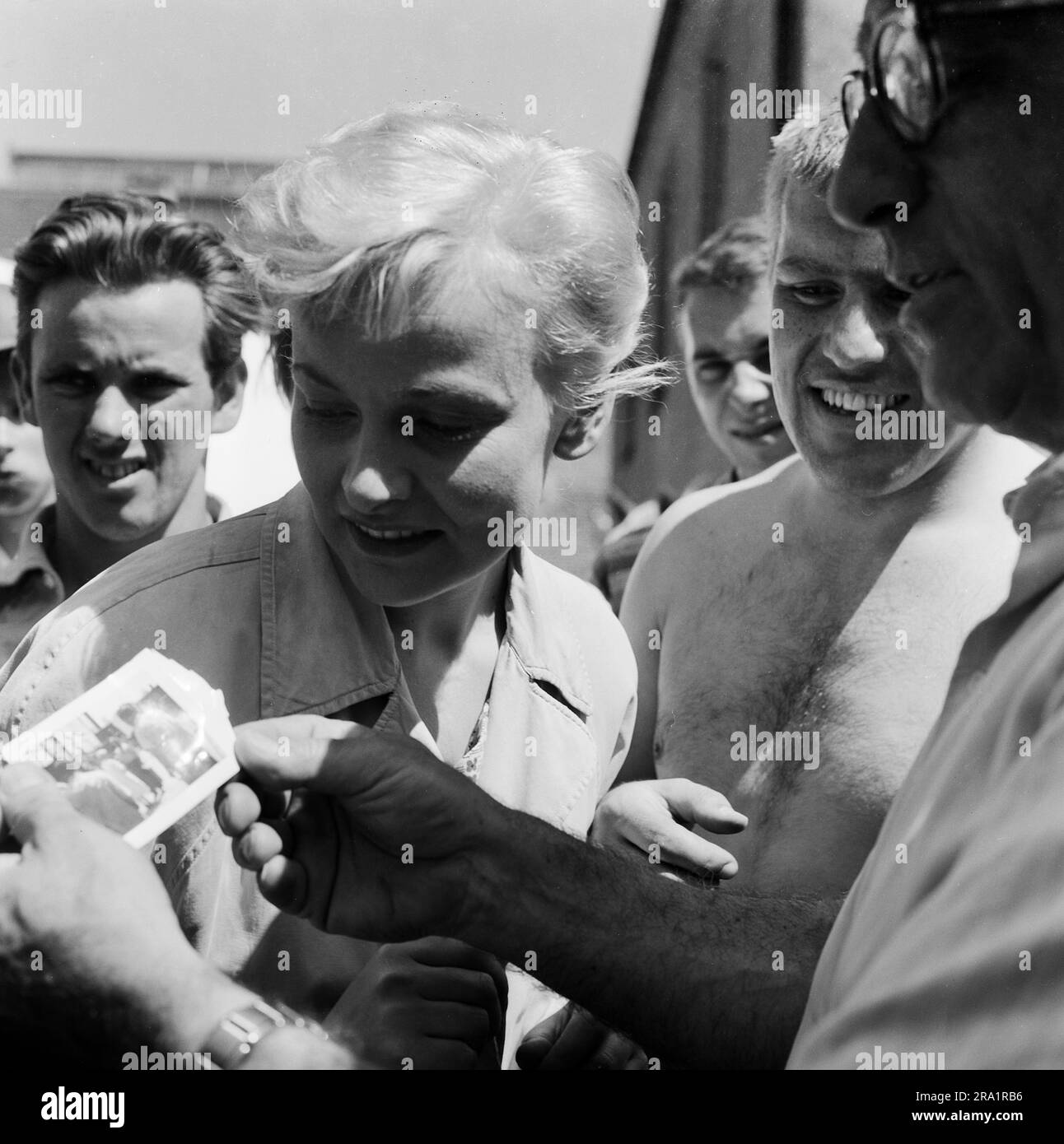 Nachts wenn der Teufel kam, Spielfilm, Deutschland 1957, Regie: Robert Siodmak, Darsteller Annemarie Düringer und Mario Adorf sehen ein Polaroid-Foto, das Siodmak (rechts) geschossen hat Stockfoto