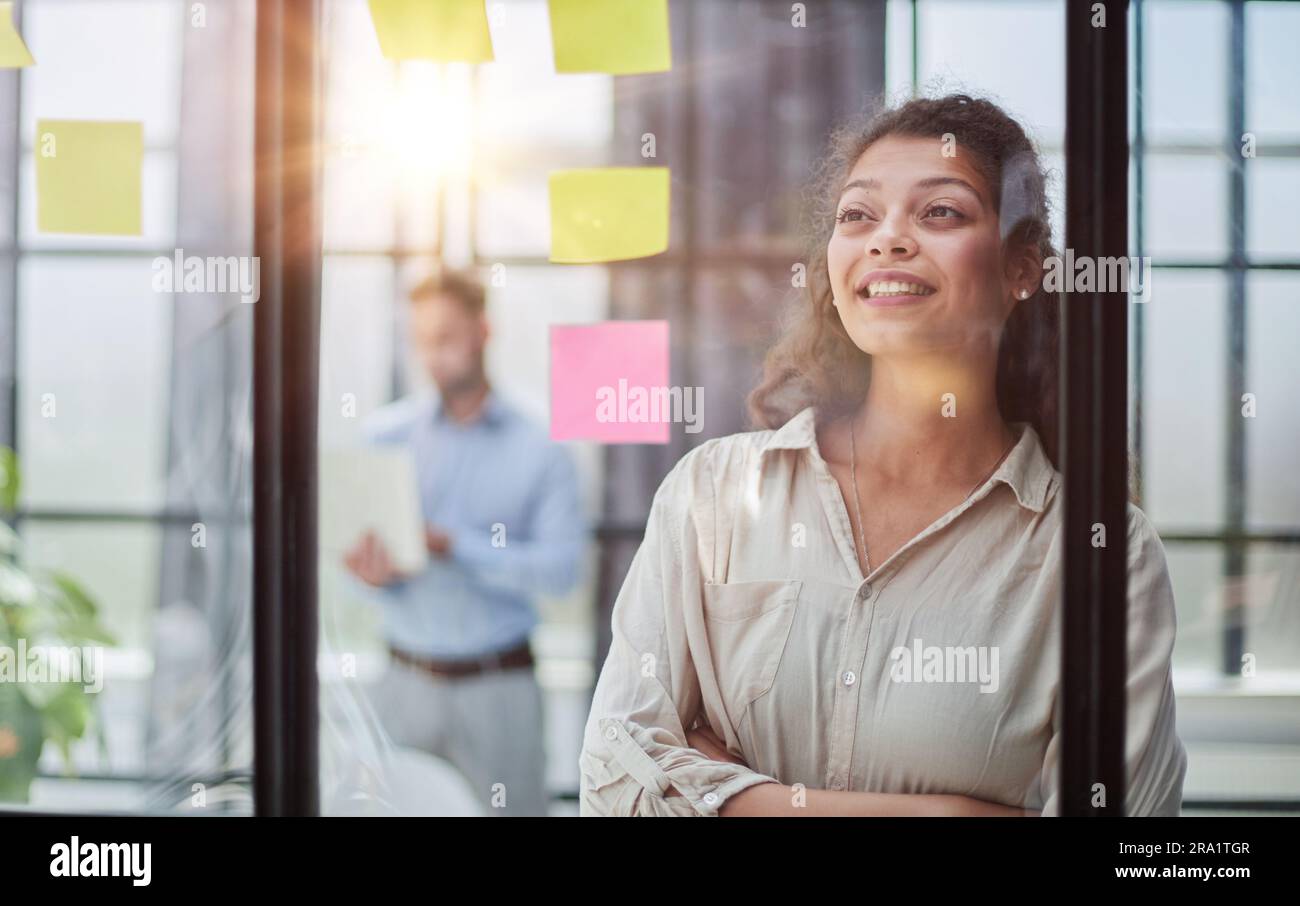 Ihre Vision zum Leben erwecken. Aufnahme einer selbstbewussten Geschäftsfrau, die ihrem Kollegen mit Haftnotizen an einer Glaswand im Büro eine Idee vorstellt. Stockfoto