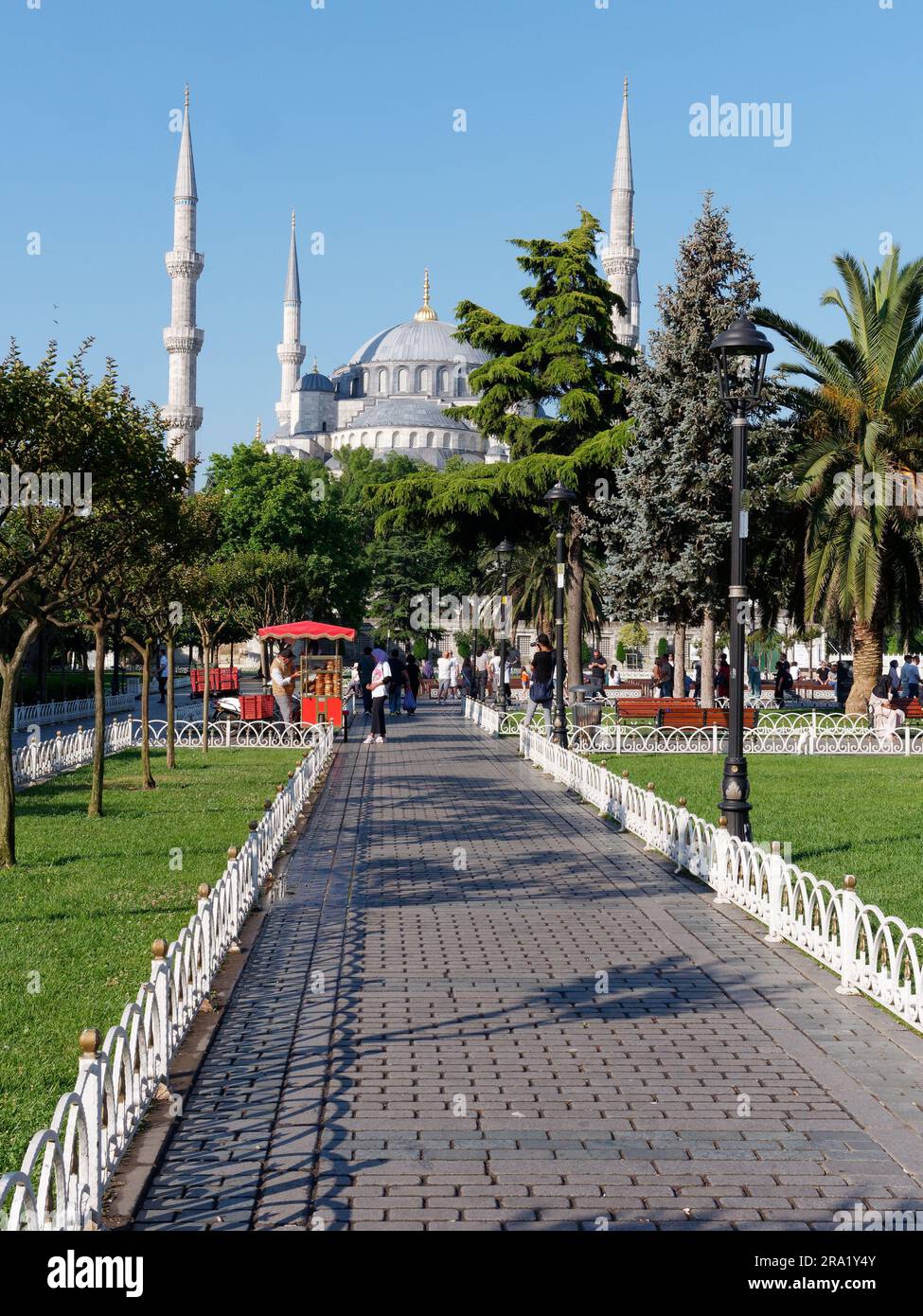 Gärten und Rote Karren, die Simits aka türkische Bagels verkaufen, mit der Sultan Ahmed aka Blaue Moschee dahinter, Sultanahmet Viertel, Istanbul, Türkei Stockfoto