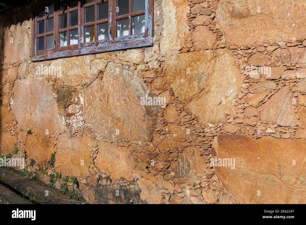 Typische Sandsteinwand eines alten Kolonialgebäudes mit Fenstern, Minas Gerais, Brasilien Stockfoto