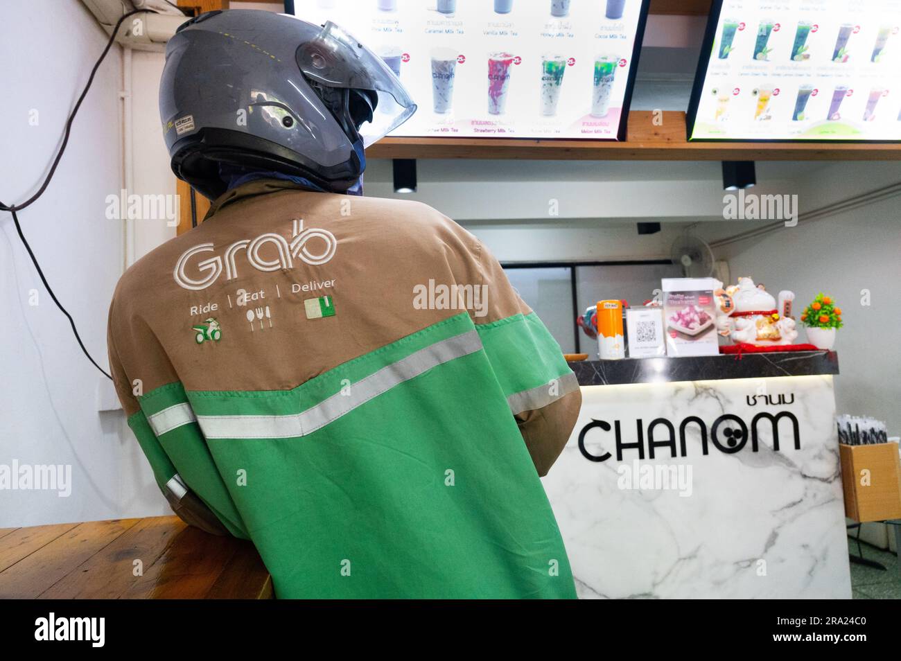 Ein Moped-Fahrer wartet auf Bestellung im Bubble Tea Cafe, Bangkok, Thailand Stockfoto