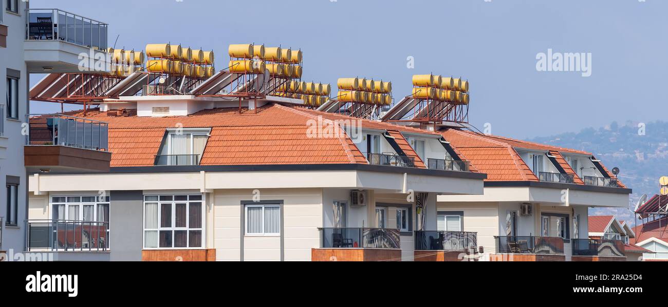 Neues Wohngebäude mit Solarwarmwasserbereiter auf dem Dach. Stadtarchitektur. Stockfoto