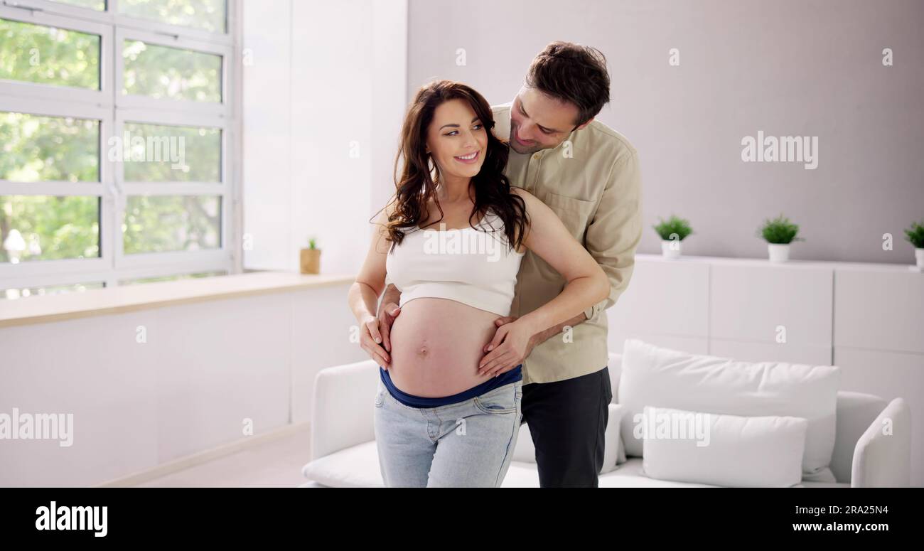 Ein Schwangeres Paar Wartet Auf Baby. Hände Auf Den Bauch Stockfoto