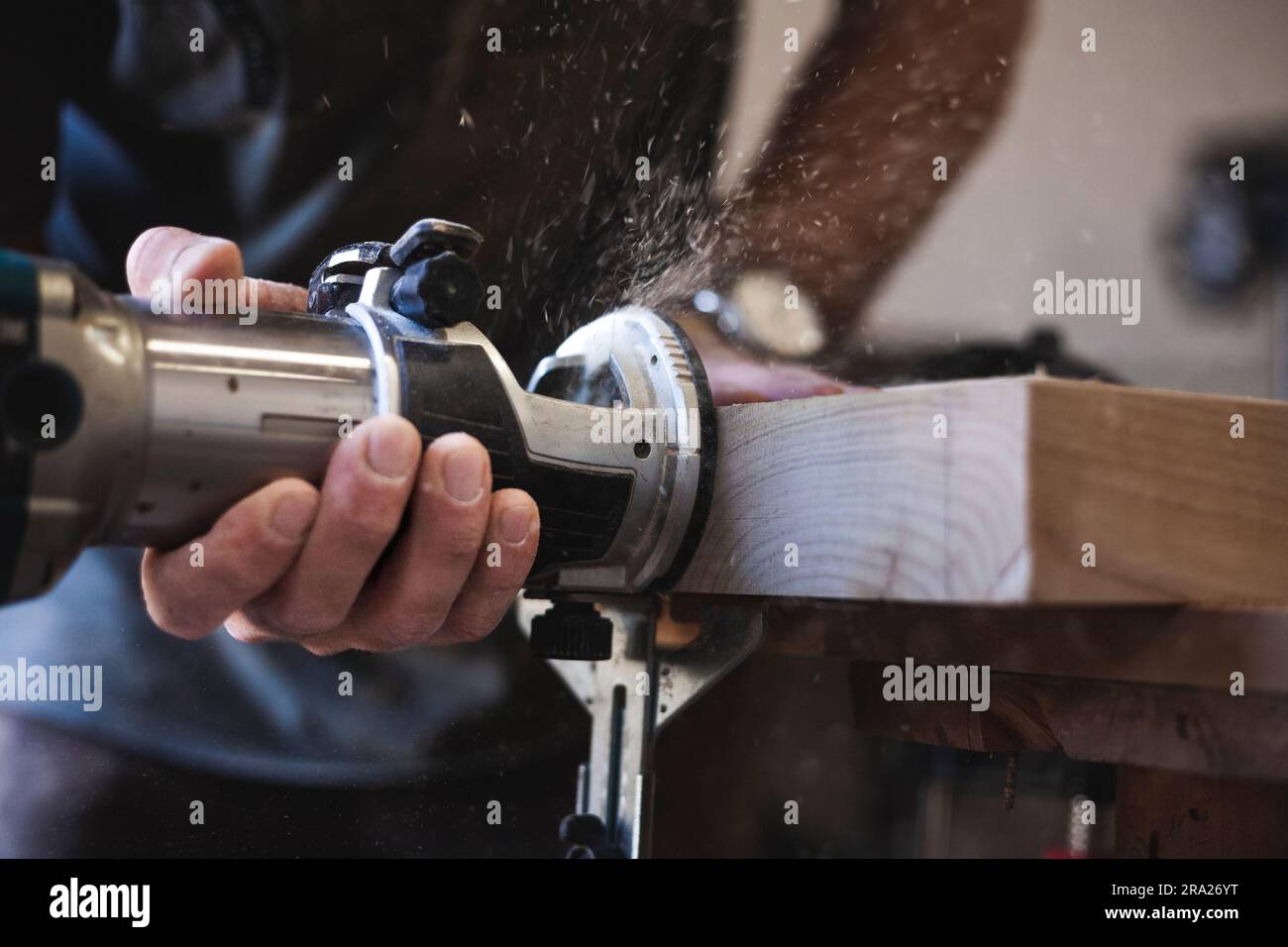 Detail eines Handwerkers, der einen Router für die Arbeit an einem Holzbrett verwendet Stockfoto