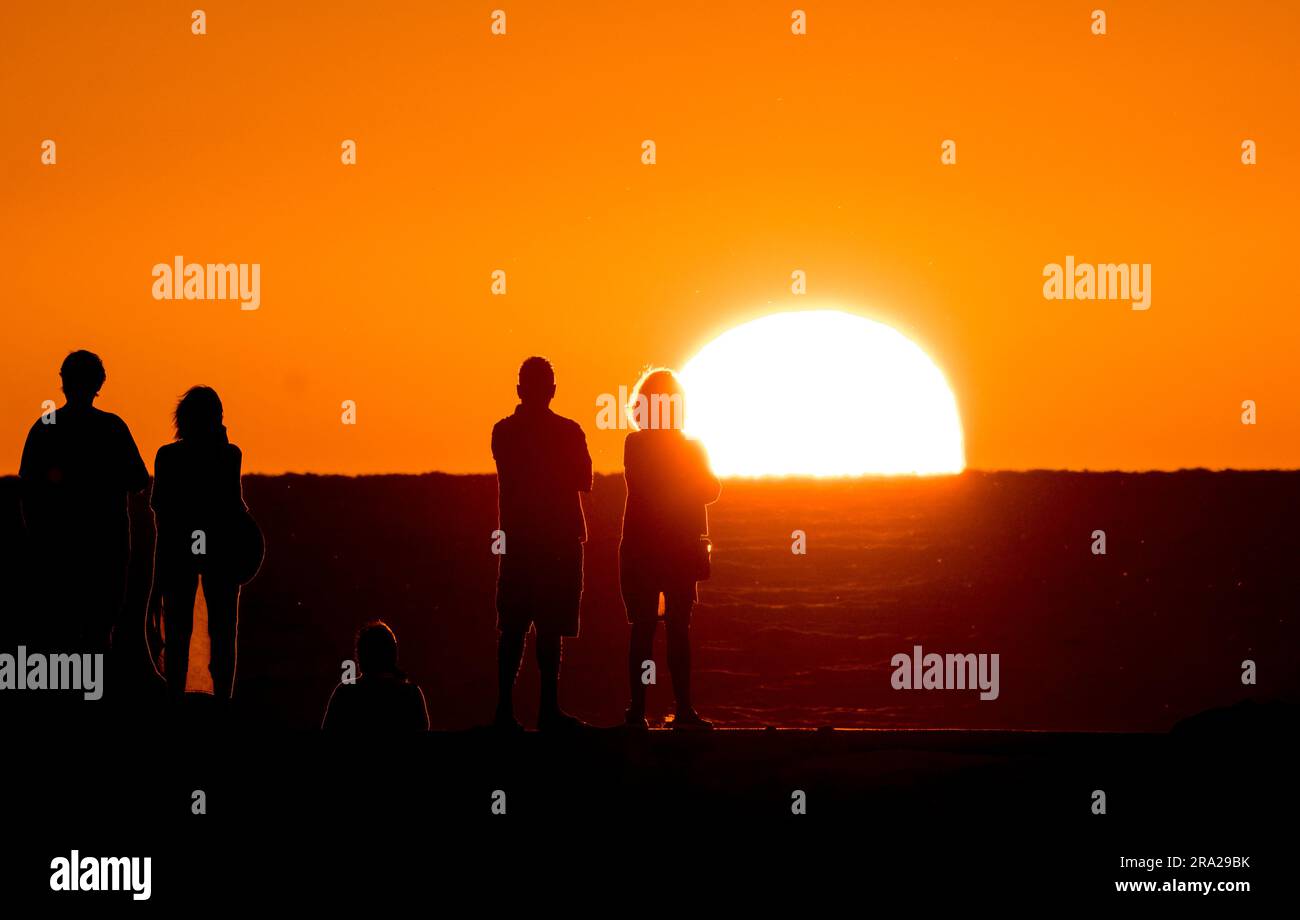 Menschen am Venice Jetty, die von der Sonne über dem Golf von Mexiko in Venice, Florida, USA, umgeben sind Stockfoto
