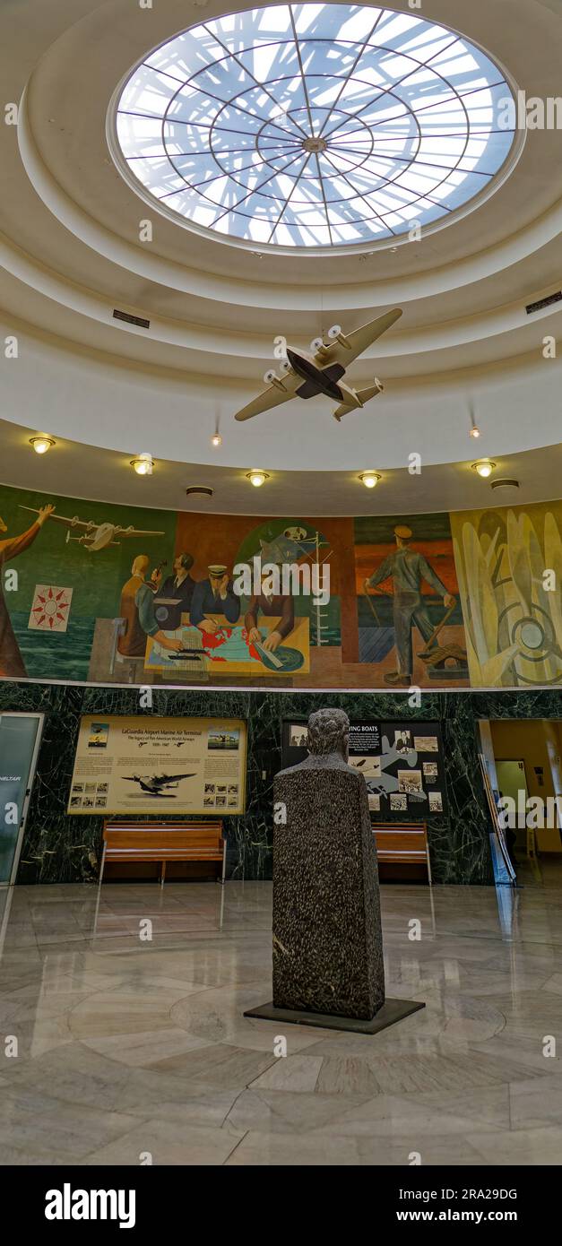 Ein Modell des Pan American Airways System „Yankee Clipper“ ist vom Oberlicht des Marine Air Terminal des Flughafens LaGuardia über dem Wandgemälde „Flight“ aufgehängt. Stockfoto