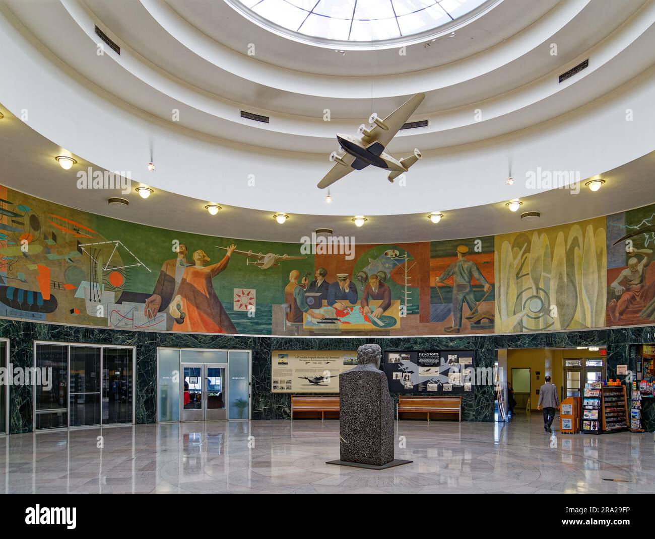 Ein Modell des Pan American Airways System „Yankee Clipper“ ist vom Oberlicht des Marine Air Terminal des Flughafens LaGuardia über dem Wandgemälde „Flight“ aufgehängt. Stockfoto