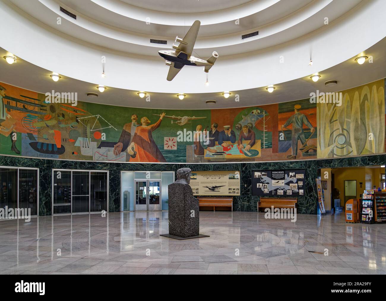 Ein Modell des Pan American Airways System „Yankee Clipper“ ist vom Oberlicht des Marine Air Terminal des Flughafens LaGuardia über dem Wandgemälde „Flight“ aufgehängt. Stockfoto
