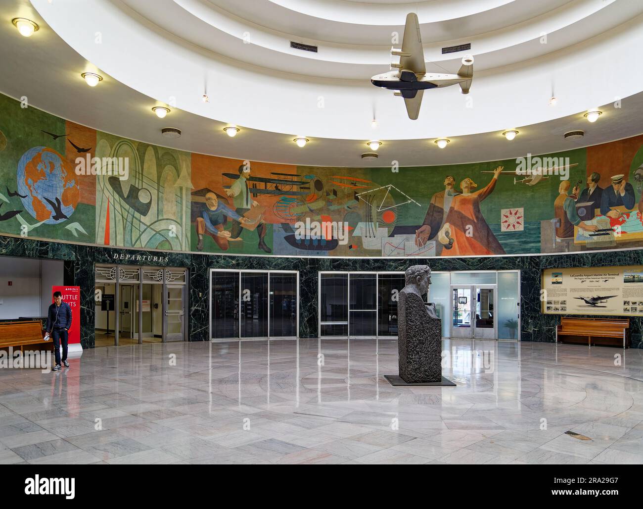 Ein Modell des Pan American Airways System „Yankee Clipper“ ist vom Oberlicht des Marine Air Terminal des Flughafens LaGuardia über dem Wandgemälde „Flight“ aufgehängt. Stockfoto