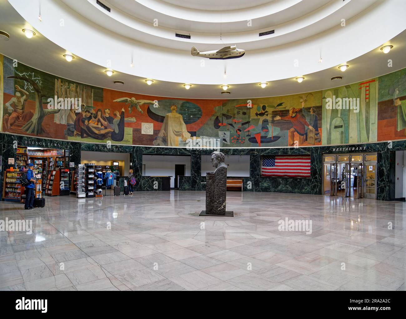 Ein Modell des Pan American Airways System „Yankee Clipper“ ist vom Oberlicht des Marine Air Terminal des Flughafens LaGuardia über dem Wandgemälde „Flight“ aufgehängt. Stockfoto