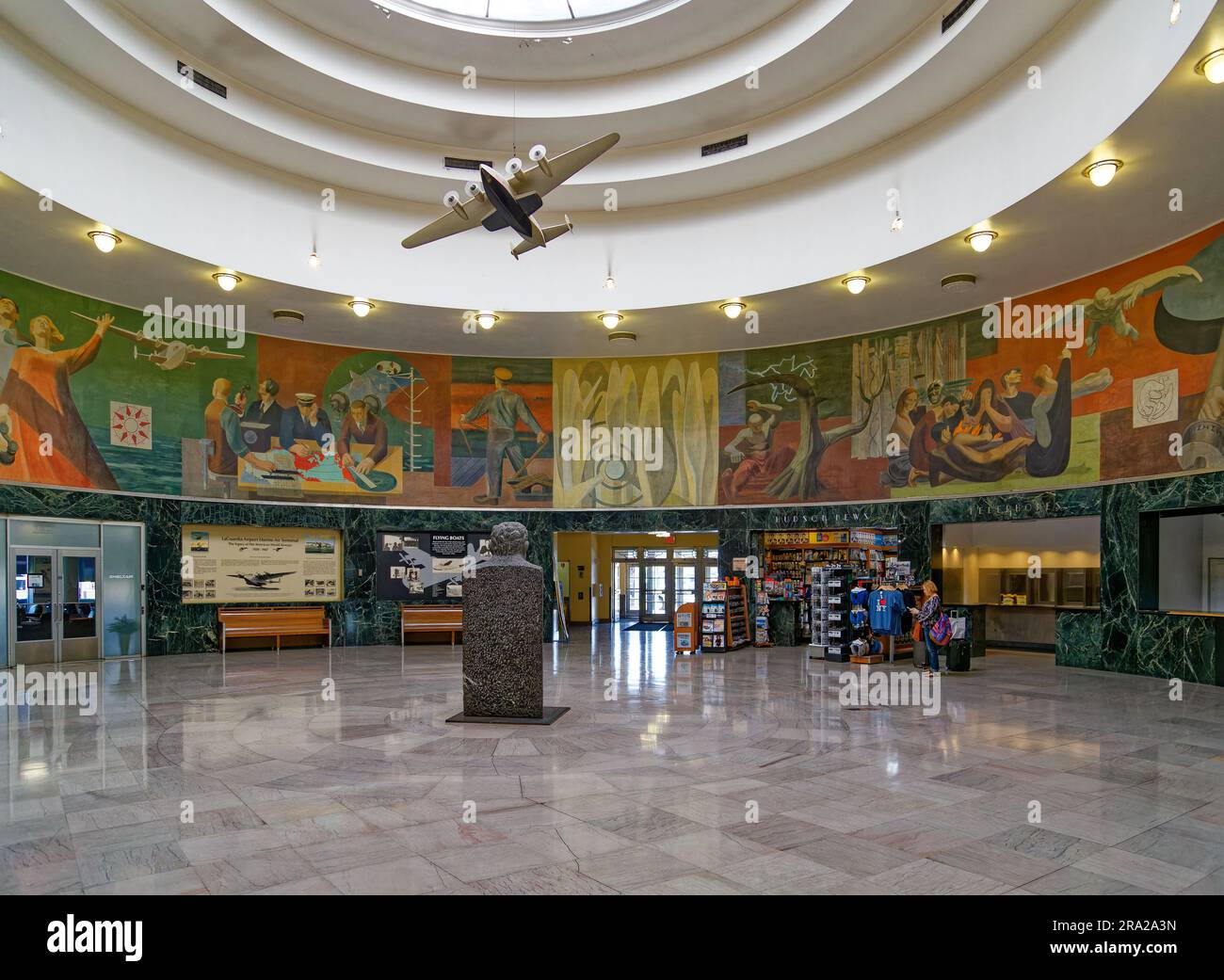 Ein Modell des Pan American Airways System „Yankee Clipper“ ist vom Oberlicht des Marine Air Terminal des Flughafens LaGuardia über dem Wandgemälde „Flight“ aufgehängt. Stockfoto