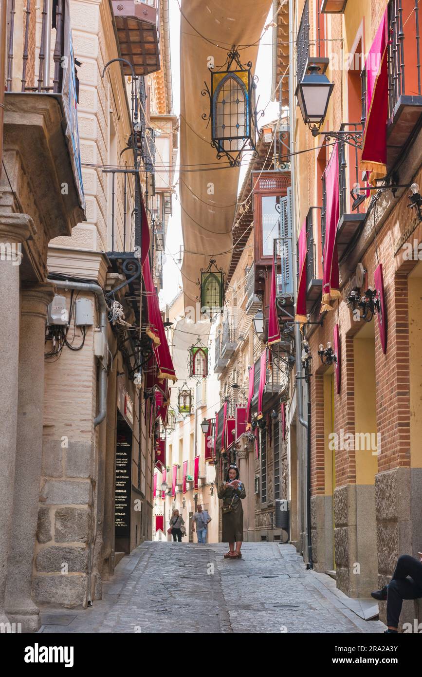 Weibliche Einzelreise, Ansicht im Sommer einer jungen Frau, die eine Karte liest, während sie in einer schmalen Straße in der historischen Altstadt von Toledo, Spanien, steht Stockfoto