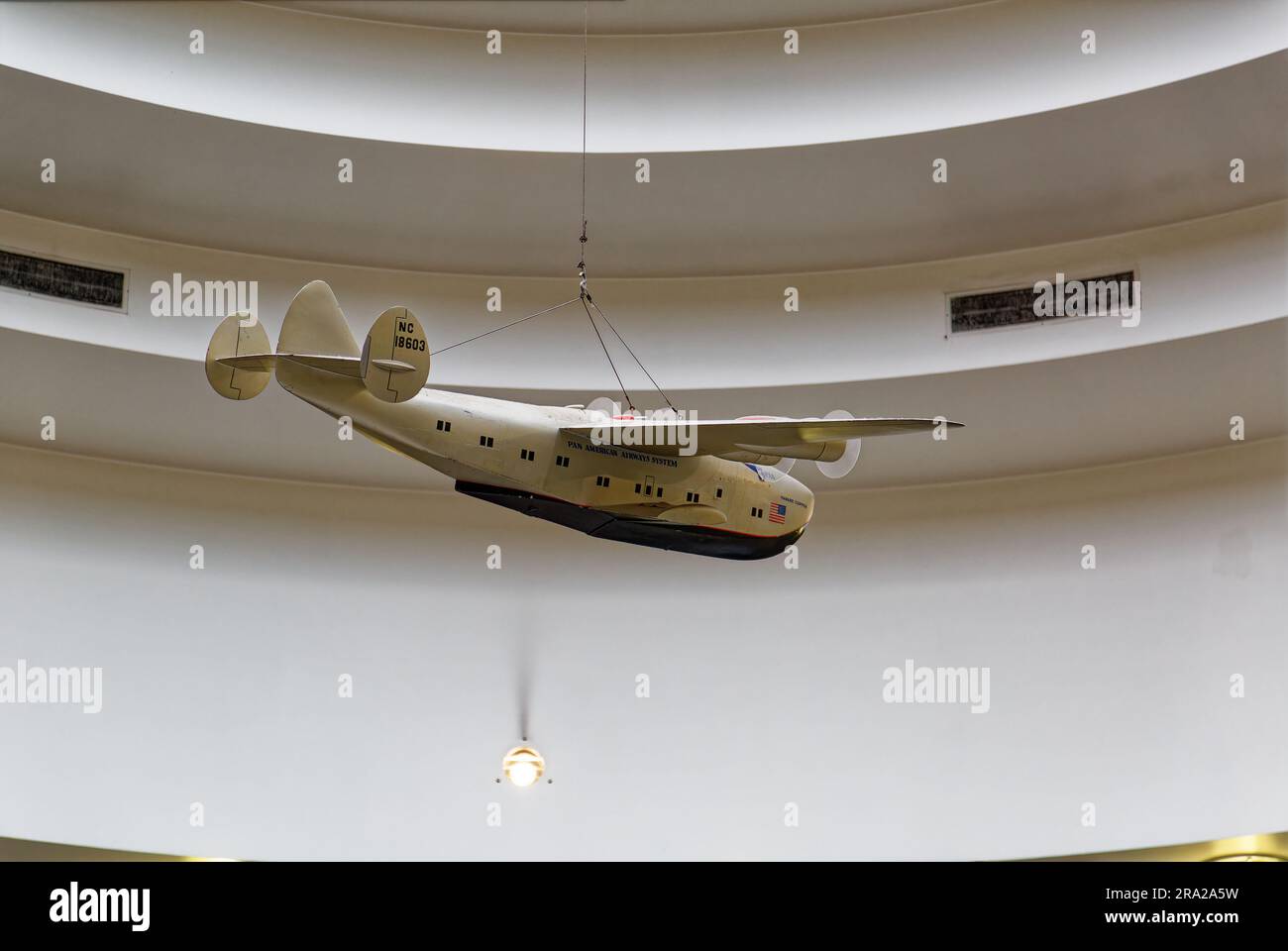 Ein Modell des Pan American Airways System „Yankee Clipper“ ist vom Oberlicht des Marine Air Terminal des Flughafens LaGuardia über dem Wandgemälde „Flight“ aufgehängt. Stockfoto