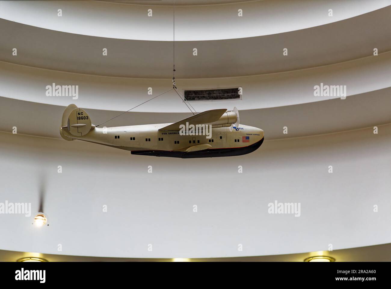 Ein Modell des Pan American Airways System „Yankee Clipper“ ist vom Oberlicht des Marine Air Terminal des Flughafens LaGuardia über dem Wandgemälde „Flight“ aufgehängt. Stockfoto