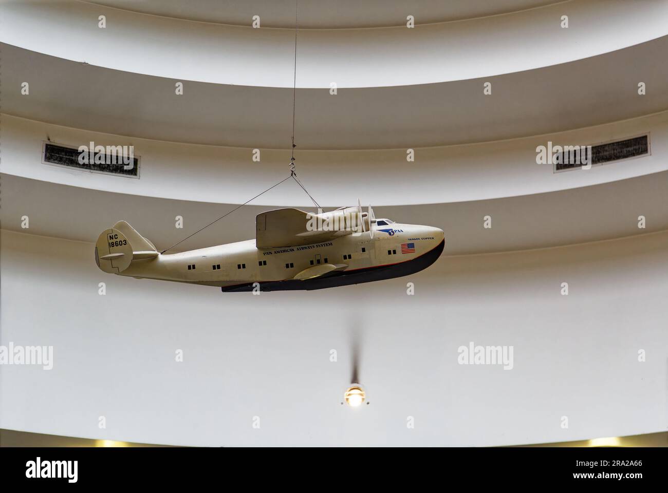 Ein Modell des Pan American Airways System „Yankee Clipper“ ist vom Oberlicht des Marine Air Terminal des Flughafens LaGuardia über dem Wandgemälde „Flight“ aufgehängt. Stockfoto