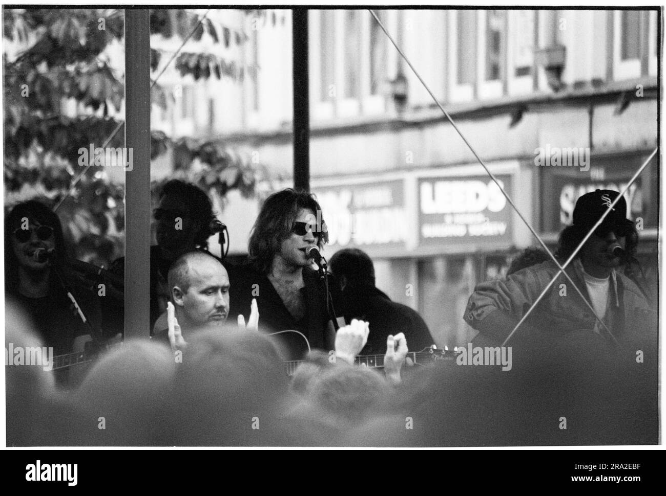 BON JOVI, FREIER AUFTRITT, CARDIFF BANDSTAND, 1995: Jon Bon Jovi von Bon Jovi spielte am 21. Juni 1995 einen kostenlosen Busking-Auftritt auf der Queen Street in Cardiff, Wales, Großbritannien. Der Auftritt war, um den schlecht verkauften Auftritt am nächsten Tag im Arms Park Stadium bekannt zu machen, und eine riesige Menschenmenge versammelte sich in Cardiff's Haupteinkaufsstraße. Foto: Rob Watkins Stockfoto