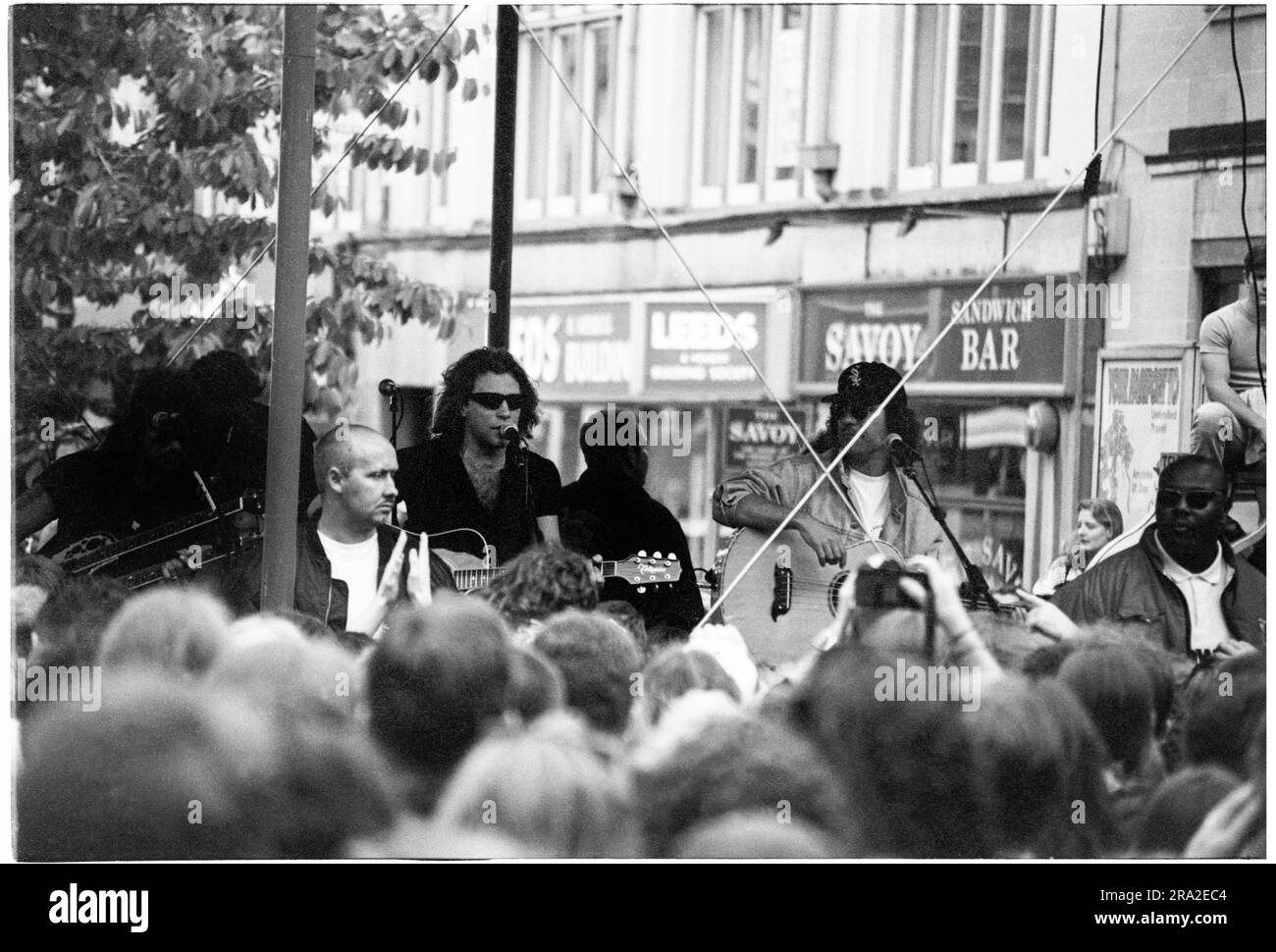 BON JOVI, FREIER AUFTRITT, CARDIFF BANDSTAND, 1995: Jon Bon Jovi von Bon Jovi spielte am 21. Juni 1995 einen kostenlosen Busking-Auftritt auf der Queen Street in Cardiff, Wales, Großbritannien. Der Auftritt war, um den schlecht verkauften Auftritt am nächsten Tag im Arms Park Stadium bekannt zu machen, und eine riesige Menschenmenge versammelte sich in Cardiff's Haupteinkaufsstraße. Foto: Rob Watkins Stockfoto