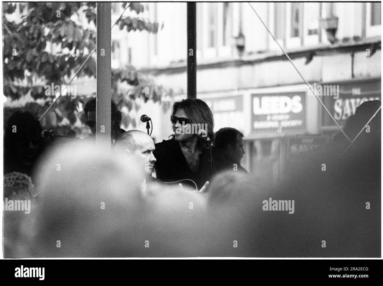 BON JOVI, FREIER AUFTRITT, CARDIFF BANDSTAND, 1995: Jon Bon Jovi von Bon Jovi spielte am 21. Juni 1995 einen kostenlosen Busking-Auftritt auf der Queen Street in Cardiff, Wales, Großbritannien. Der Auftritt war, um den schlecht verkauften Auftritt am nächsten Tag im Arms Park Stadium bekannt zu machen, und eine riesige Menschenmenge versammelte sich in Cardiff's Haupteinkaufsstraße. Foto: Rob Watkins Stockfoto