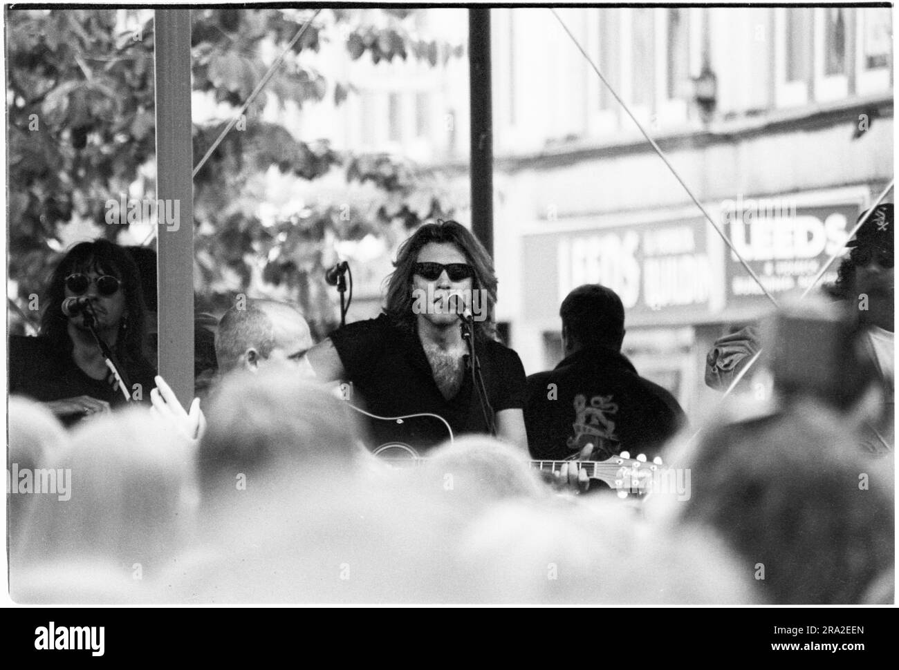 BON JOVI, FREIER AUFTRITT, CARDIFF BANDSTAND, 1995: Jon Bon Jovi von Bon Jovi spielte am 21. Juni 1995 einen kostenlosen Busking-Auftritt auf der Queen Street in Cardiff, Wales, Großbritannien. Der Auftritt war, um den schlecht verkauften Auftritt am nächsten Tag im Arms Park Stadium bekannt zu machen, und eine riesige Menschenmenge versammelte sich in Cardiff's Haupteinkaufsstraße. Foto: Rob Watkins Stockfoto