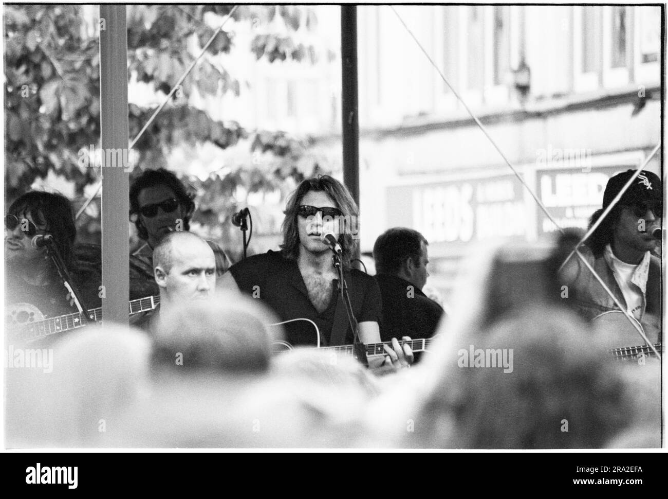 BON JOVI, FREIER AUFTRITT, CARDIFF BANDSTAND, 1995: Jon Bon Jovi von Bon Jovi spielte am 21. Juni 1995 einen kostenlosen Busking-Auftritt auf der Queen Street in Cardiff, Wales, Großbritannien. Der Auftritt war, um den schlecht verkauften Auftritt am nächsten Tag im Arms Park Stadium bekannt zu machen, und eine riesige Menschenmenge versammelte sich in Cardiff's Haupteinkaufsstraße. Foto: Rob Watkins Stockfoto