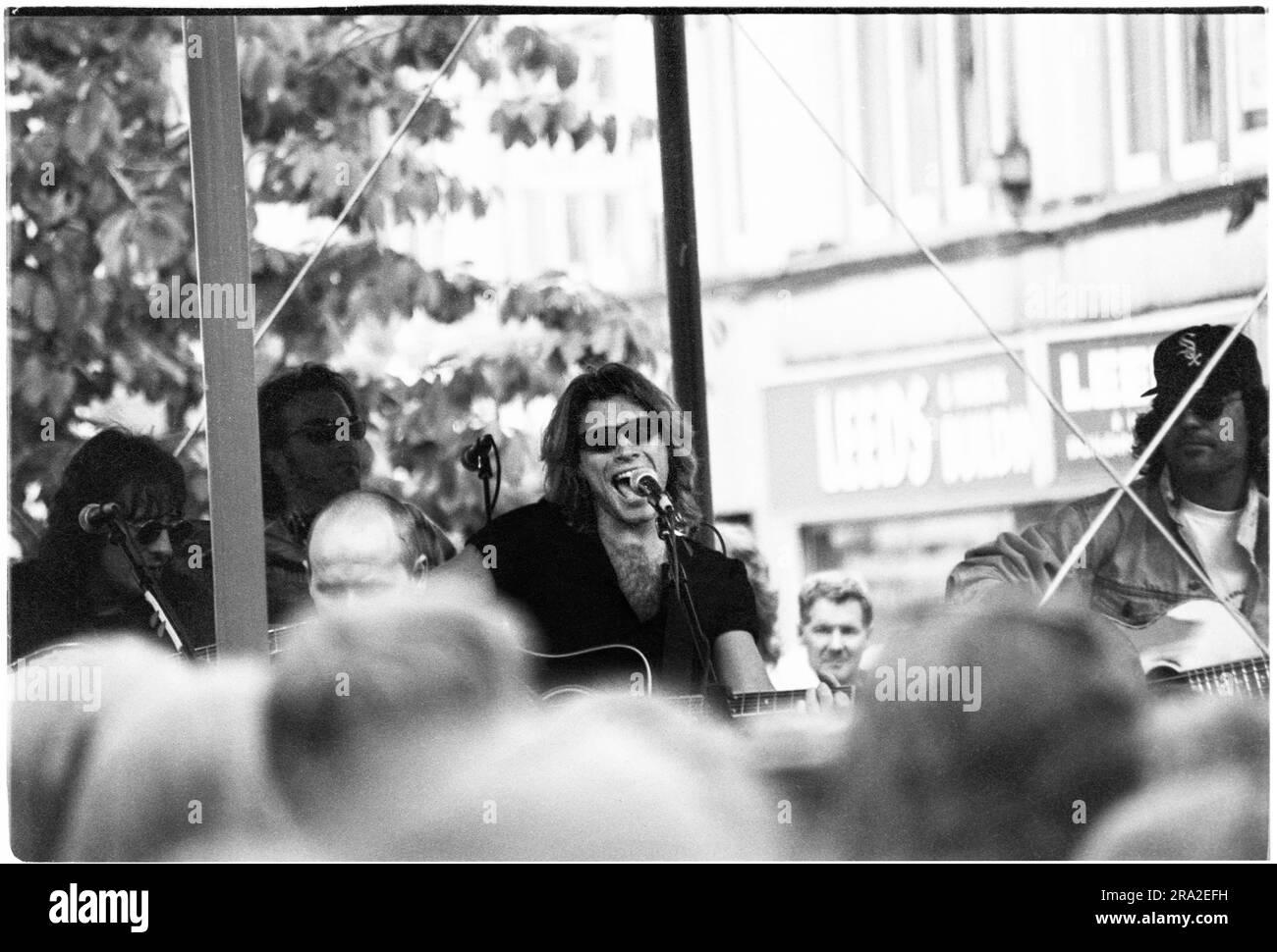 BON JOVI, FREIER AUFTRITT, CARDIFF BANDSTAND, 1995: Jon Bon Jovi von Bon Jovi spielte am 21. Juni 1995 einen kostenlosen Busking-Auftritt auf der Queen Street in Cardiff, Wales, Großbritannien. Der Auftritt war, um den schlecht verkauften Auftritt am nächsten Tag im Arms Park Stadium bekannt zu machen, und eine riesige Menschenmenge versammelte sich in Cardiff's Haupteinkaufsstraße. Foto: Rob Watkins Stockfoto