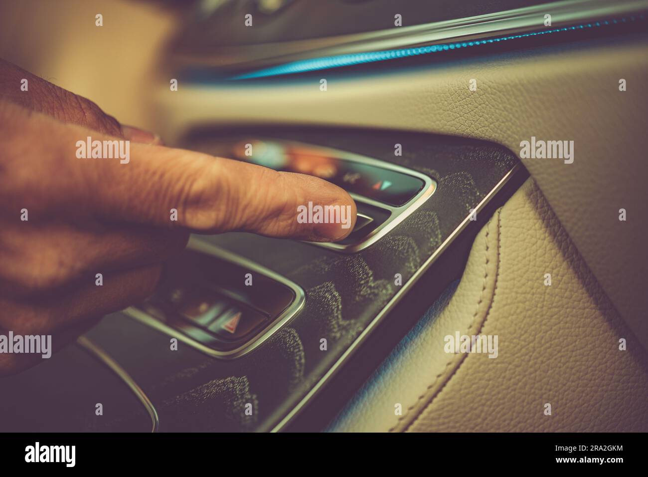 Kaukasische Fahrer-Klimaregelung. Finger auf eine Taste Nahaufnahme. Thema Fahrzeugtechnik. Stockfoto