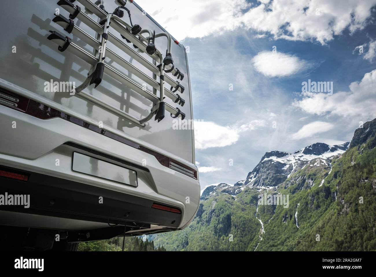 Moderner, halbintegraler Camper-Van auf dem Roadtrip. Rückansicht mit malerischen Bergen im Hintergrund. Fahrradständer – Nahaufnahme. Stockfoto