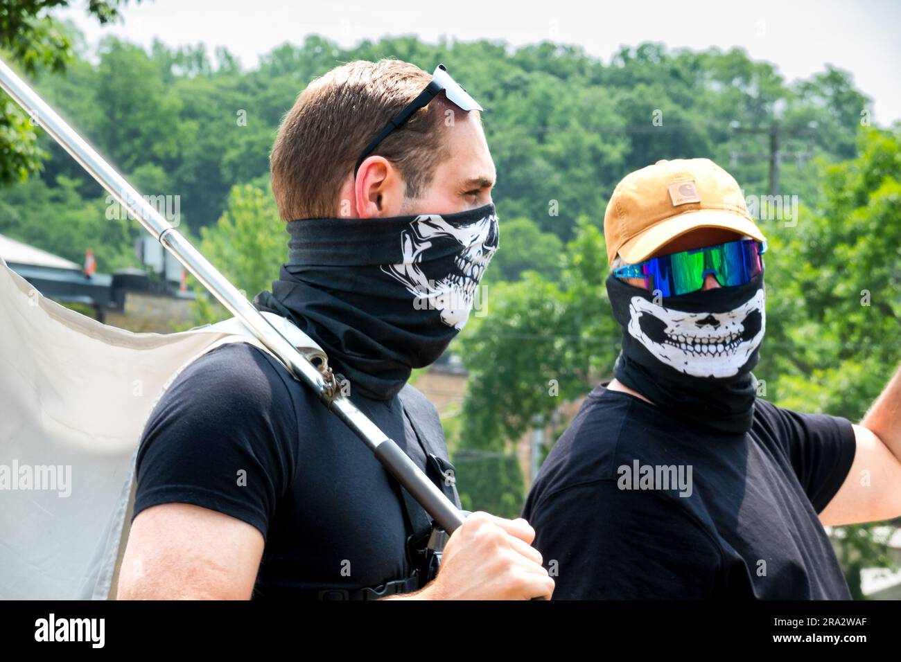 HUDSON, WI, USA - 17. JUNI 2023: Unidentifizierte maskierte Anti-LGBTQ+-Demonstranten bei der Hudson-Pride-Feier. Stockfoto