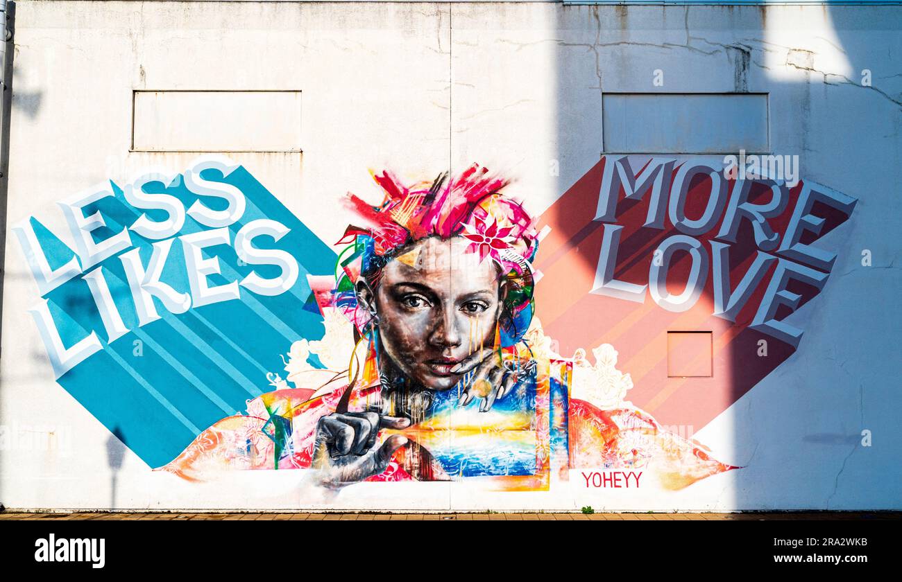 Wandgemälde des Osaka-Künstlers Yoheyy, „Less Likes, More Love“ an einer Lagerwand im Meriken Park am Ufer von Kobe, Japan. Stockfoto