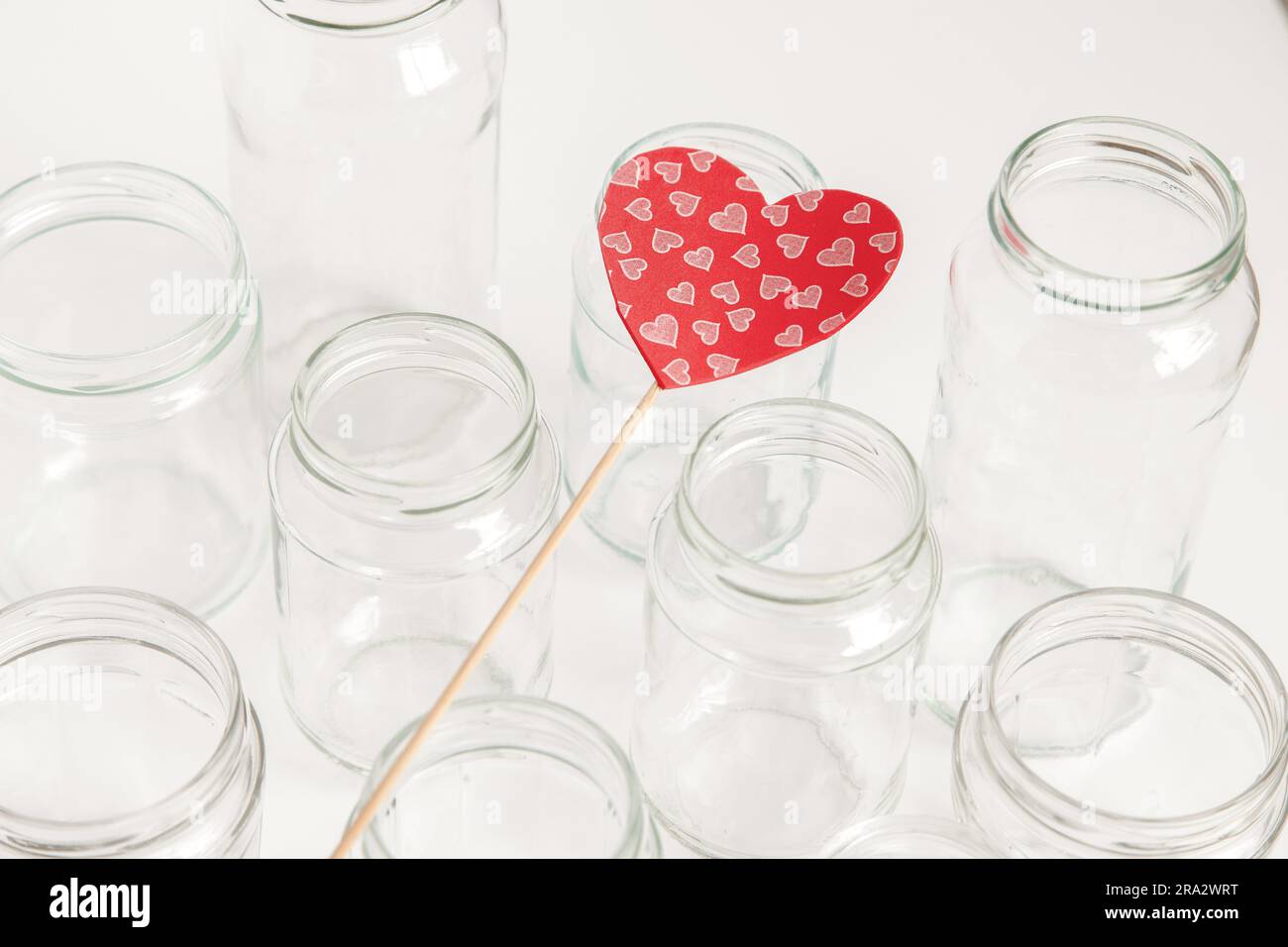 Verschiedene Glasbehälter ohne Deckel auf weißem Hintergrund, Recycling. Konzept der zweiten Lebensdauer von Werkstoffen, verschiedene Anwendungsmöglichkeiten für Glasfläschchen. Stockfoto