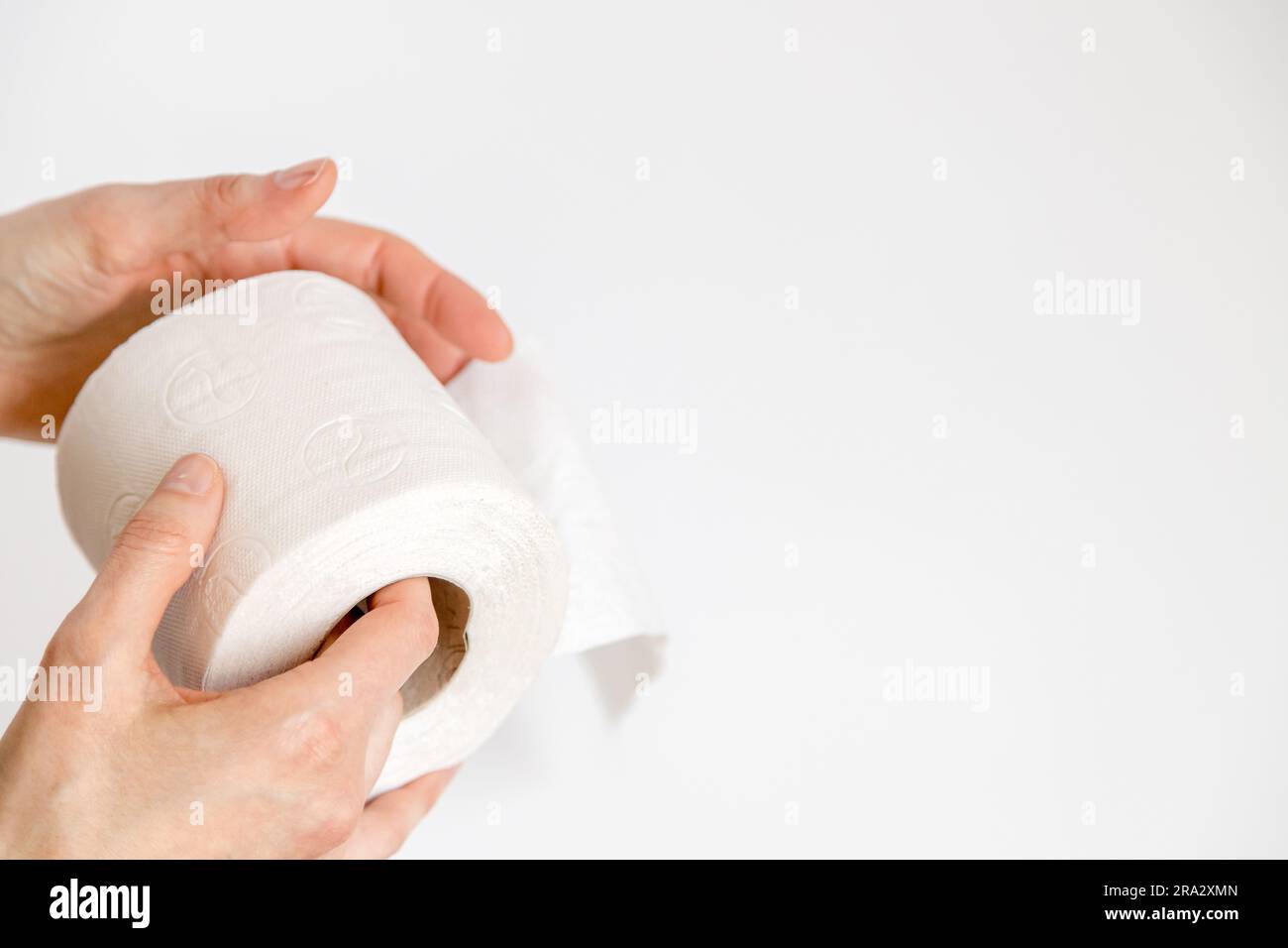 Nahaufnahme einer Person, die eine recycelte Toilettenpapierrolle auf weißem Hintergrund in der Hand hält. Umweltbewusstsein und Konzept der nachhaltigen Nutzung. Stockfoto